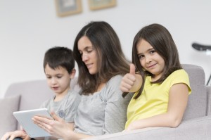 Smiling mother and children using tablet